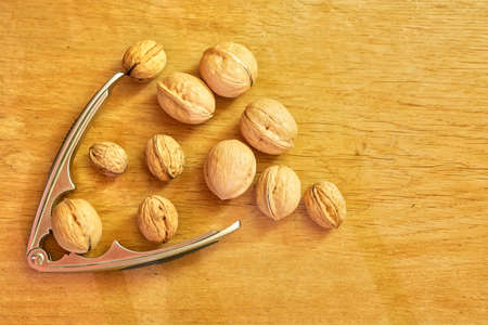 Walnuts and nutcracker on a wooden background.の写真素材