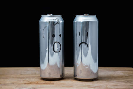 One tells another how they beat him. Concept Aluminum cans. People are empty inside. Drawn emotions. Sadness and indignationの写真素材