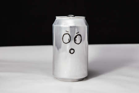 Concept of dumbfounded man. confused emoticon on aluminium 0.25l can, Emoji with surprised face. On black backgroundの写真素材