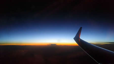 Blue orange sunset from a sky height. Airplane wing.
