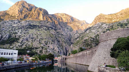 Fortification Wall Of Adriatic ancient Town Kotor in Montenegro. Castle walls and river. In reflection on waterの写真素材