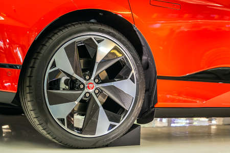 Singapore. March 2019. Orange Jaguar I-Pace all electric SUV. Side view. Carbon wheels R22 with...