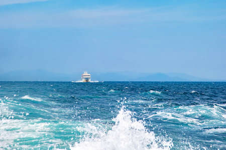 White cruise ship sailing on the sea on a sunny day. Mountains on background. Blue cloudless sky and sea, Summer leisureの写真素材