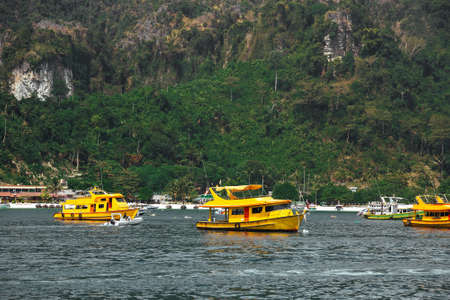 Three yellow passenger tourist speed boat, cruising near beach. Sea taxi
