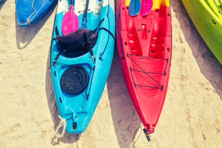 Multi colored kayaks with paddles on the sand near the sea. Top viewの写真素材