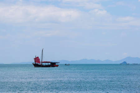Black sailing ship with red sails sailing on the blue sea.の写真素材