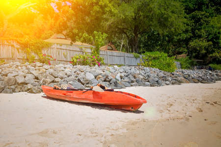 Red sea kayak at the tropical sand beach. Near coastal shaft of stones. Sunny dayの写真素材