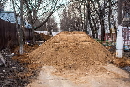 Big pile of sand on a footpath. Workers flooded the passage. Problems are not high-quality road...