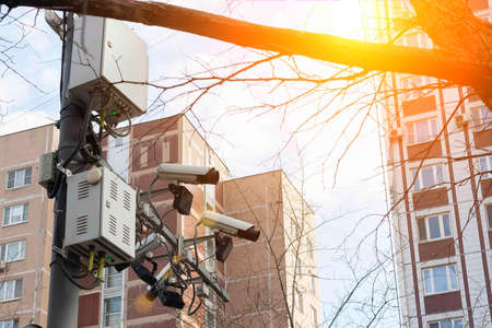 Road and lane tracking cameras hang over the roadway. Against the backdrop of urban high-rise buildingsの写真素材