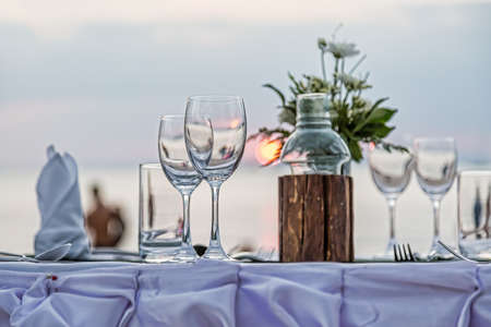 Serving for a romantic dinner on the beach at sunset.