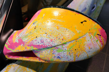 Moscow, Russia - April 30, 2019: Multicolored Porsche 911 in showroom. The car is painted with a brush by the artist in different colors. Splashes in abstract style. Side mirrorsのeditorial素材