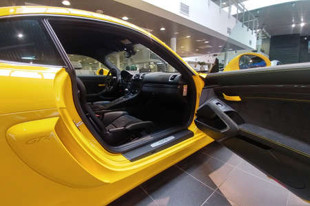 Russia, Moscow - May 04, 2019: Open door and Interior of Yellow Porsche Cayman GT4. Racing car in...