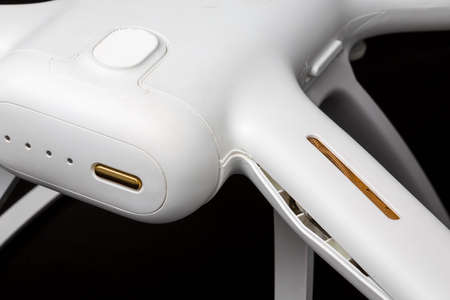 Broken white drone after a fall. Isolated on a black background. Damaged body close-up