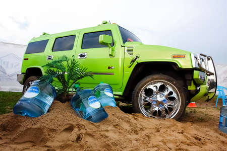 Moscow, Russia - May 25, 2019: Green tuning huge chrome wheels Hammer H2 stands on the sand.
