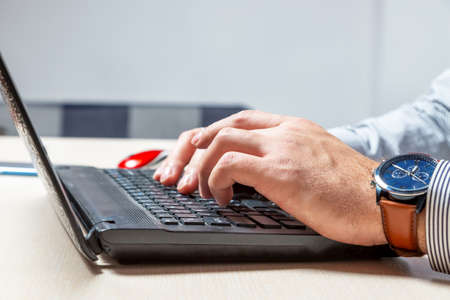A man types on the keyboard. Hands and fingers on buttons close up