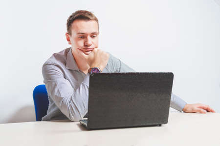 Matte toned image. young businessman working on laptop in office, being concerned