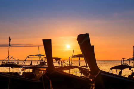 Very beautiful sunrise on a tropical island. Marina, are wooden boats. Blue clear sky and golden sunny tones.の写真素材