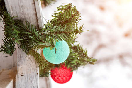 Christmas and New Year decorations on the street in the snow. A mint and red balls of garland in the...