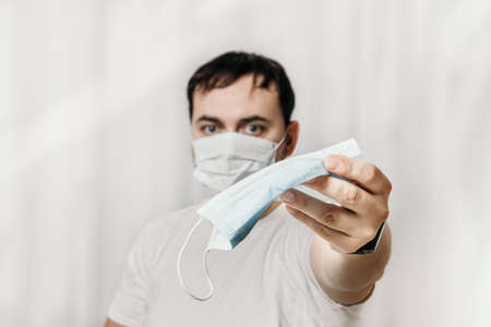 man in medical field, wearing a face mask, offering some face masksの写真素材