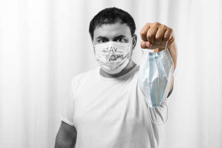 man in medical field, wearing a face mask, offering some face masks Black and white background