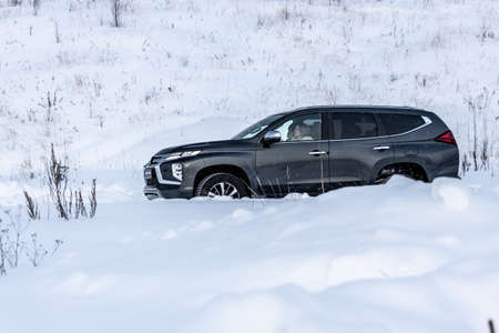 Moscow, Russia - February 17, 2021: All new Mitsubishi Pajero Sport. Facelifted suv. Side and backside view. winter, the car is driving off-road.のeditorial素材