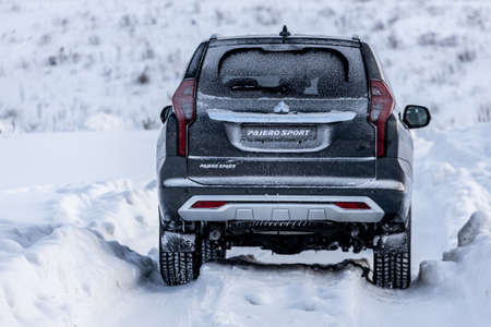 Moscow, Russia - February 17, 2021: All new Mitsubishi Pajero Sport. Facelifted suv. Side and backside view. winter, the car is driving off-road.のeditorial素材
