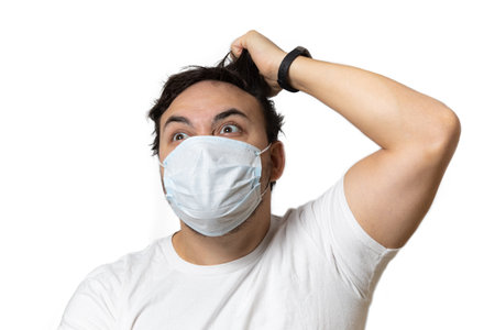 A man in a medical mask is playing a console. in the hands of a joystick. quarantine and isolation.の写真素材