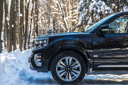 Moscow, Russia - February 15, 2021: Kia Mohave 2021 black SUV parked in the forest in winter....