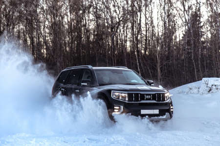 MOSCOW, RUSSIA - FEBRUARY 15, 2021: Kia Mohave 2021 black SUV drives in a controlled drift. Drift on four-wheel drive. winter, drifts. Side viewのeditorial素材