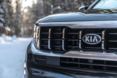 Moscow, Russia - February 15, 2021: Kia Mohave 2021 black SUV parked in the forest in winter. Close-up. LED headlights, radiator grill.のeditorial素材
