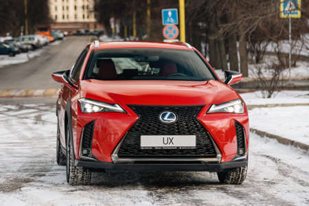 Russia, Moscow - February 05, 2020: Red premium crossover hatchback Lexus UX on the city streets. Hybrid car in winter.のeditorial素材