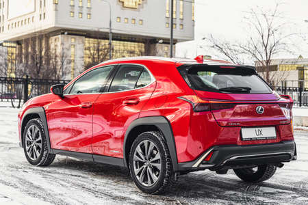 Russia, Moscow - February 05, 2020: Red premium crossover hatchback Lexus UX on the city streets. Hybrid car in winter.のeditorial素材