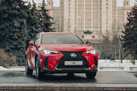 Russia, Moscow - February 05, 2020: Red premium crossover hatchback Lexus UX on the city streets. Hybrid car in winter.のeditorial素材