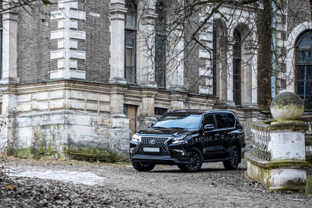 Moscow, Russia - December 03, 2020: The new Lexus GX460 2020 stands on the street opposite the floor of a ruined estate. Black luxury premium SUV Three-quarter front.のeditorial素材