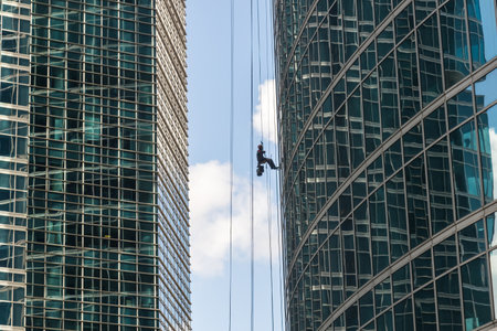 industrial mountaineering. Window cleaner performs work between two skyscrapersの写真素材