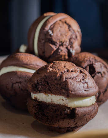 Broken cookies and stack of sponge cookies with cream on paperの写真素材