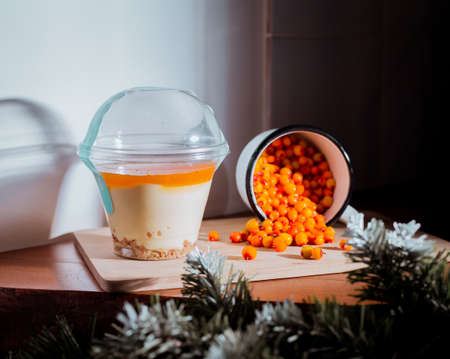 Cheesecake dessert with sea ââbuckthorn in cup, at cafe.の写真素材