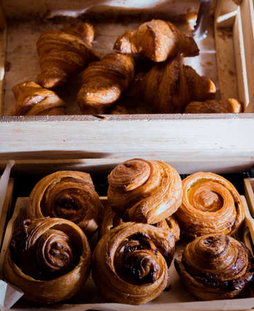 Bun with cinnamon and nuts lying on the wooden table in cafe.の写真素材