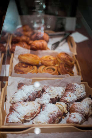 Croissants with almonds and buns soft focus, vertical top viewの写真素材
