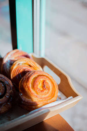 Bun with cinnamon and nuts lying on the wooden table in cafe.の写真素材