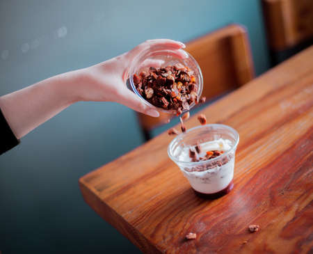 Desserts with nuts in hands, cafe background soft focus.の写真素材