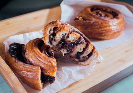 Bun with cinnamon and chocolate lying on the wooden table in cafe.の写真素材