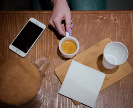 Espresso cup in hand on the table, cafe backgroundの写真素材