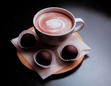 Cacao with latte-art on the table and candy.