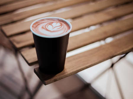 Coffee cup on wood table, in cafe.の写真素材