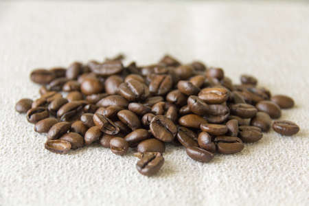 Fresh whole coffee beans on a grey clothの写真素材