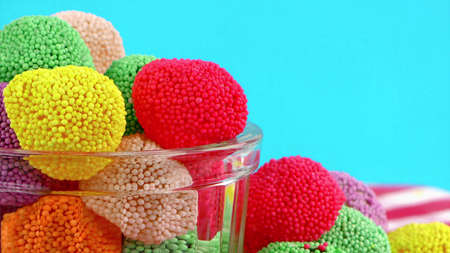 Sweet, colorful jelly raspberry in painted sugar balls lies on the table cloth