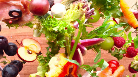 Many bright, fresh fruits and vegetables are laid out next to each other in one photoの写真素材