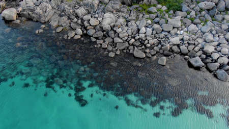 Top view close-up on turquoise water on the stone coast of the island