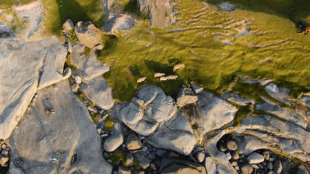 Close-up top view of an unusual stone landscape partially covered with grassの写真素材